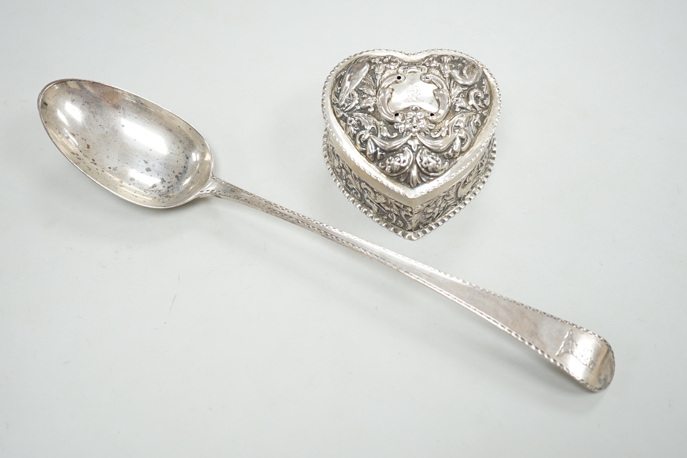 A George III silver Old English pattern bright cut engraved silver basting spoon, Sumner & Crossley, London, 1776 and a later repousse heart shaped trinket box.